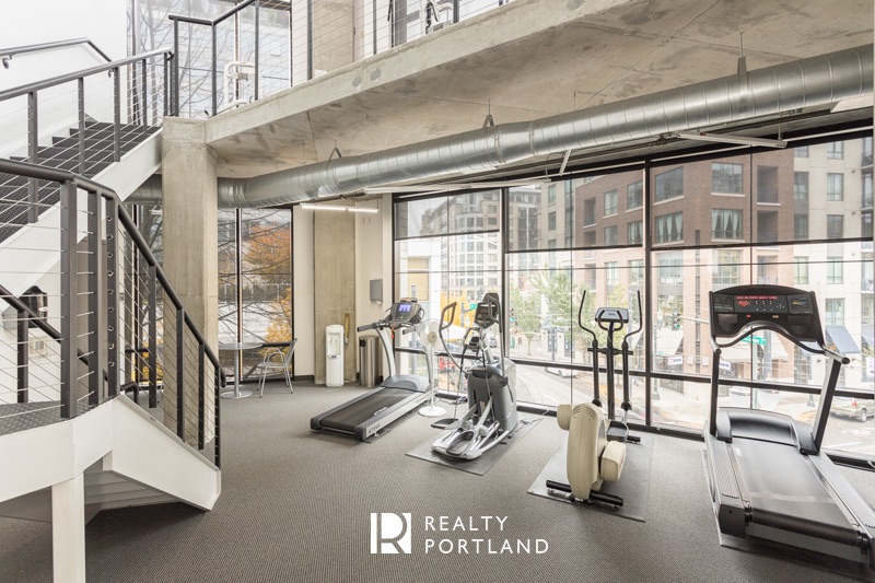 Streetcar Lofts fitness center with cardio equipment and industrial windows